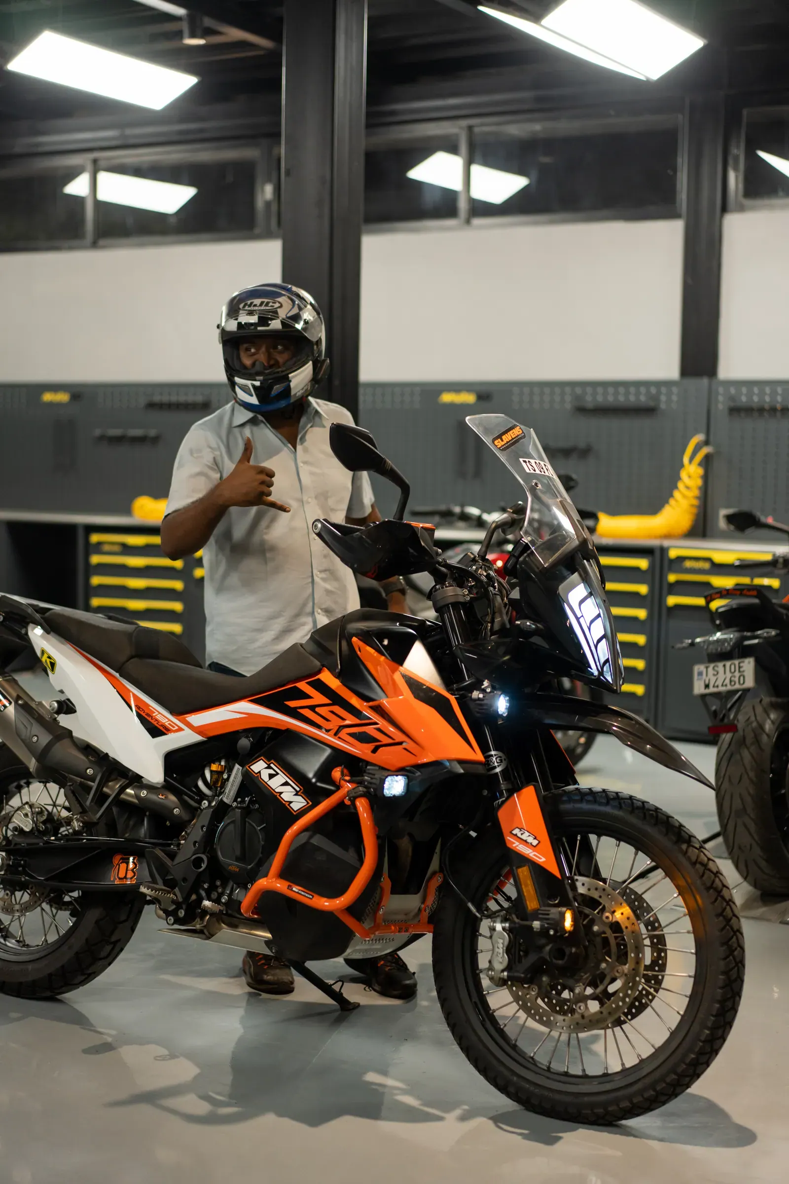 A helmeted rider standing beside their KTM adventure motorcycle at Moto40